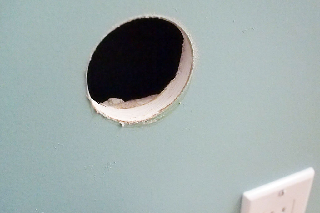 В стене дыра в дыре глаза. Отверстие в стене. Круглая дыра в стене. Круглое отверстие в стене. Небольшая сквозная дырка в бетонной стене.